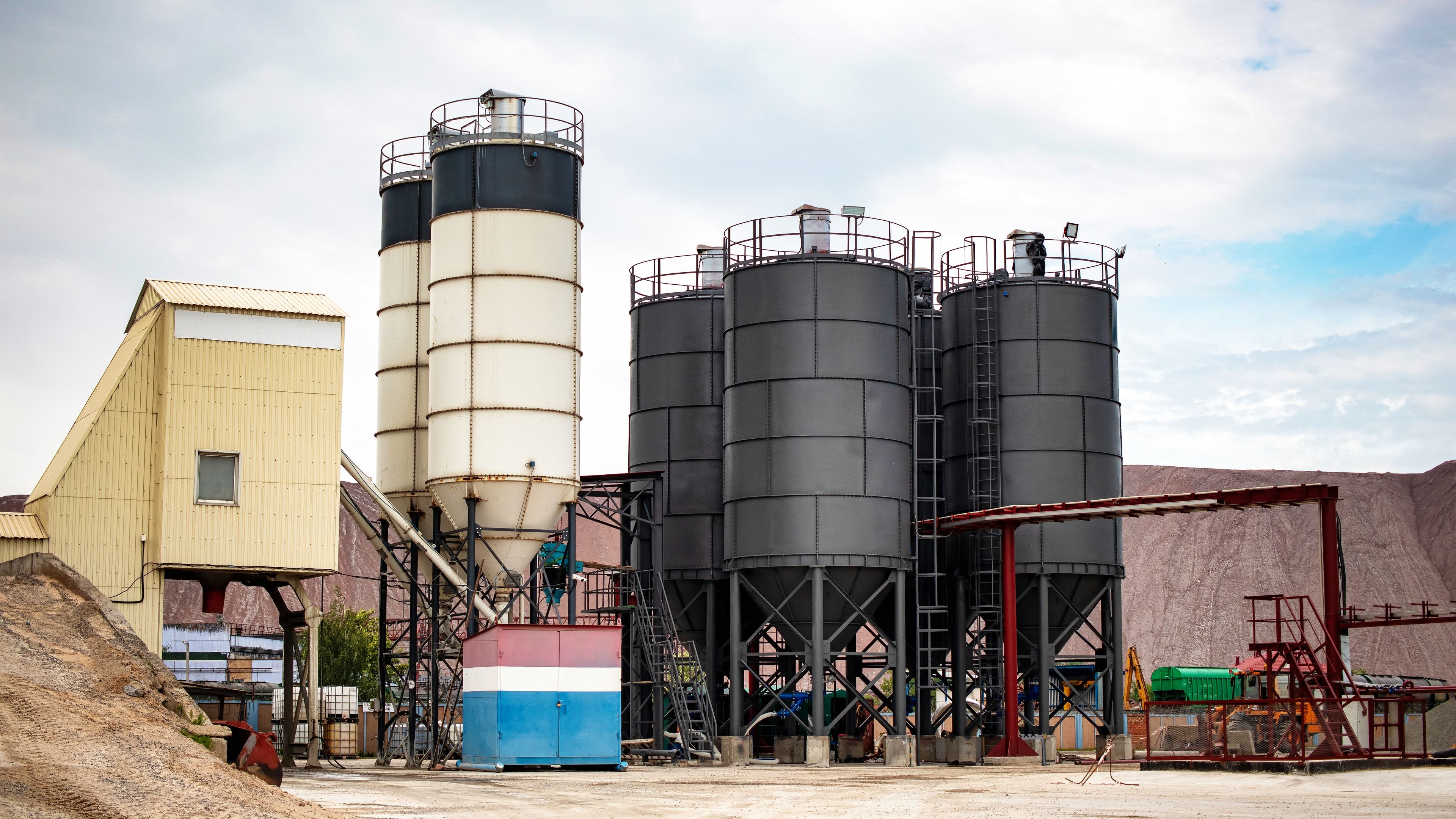 Central de hormigonado fija con silos de cemento, tolvas de áridos y estructura de dosificación