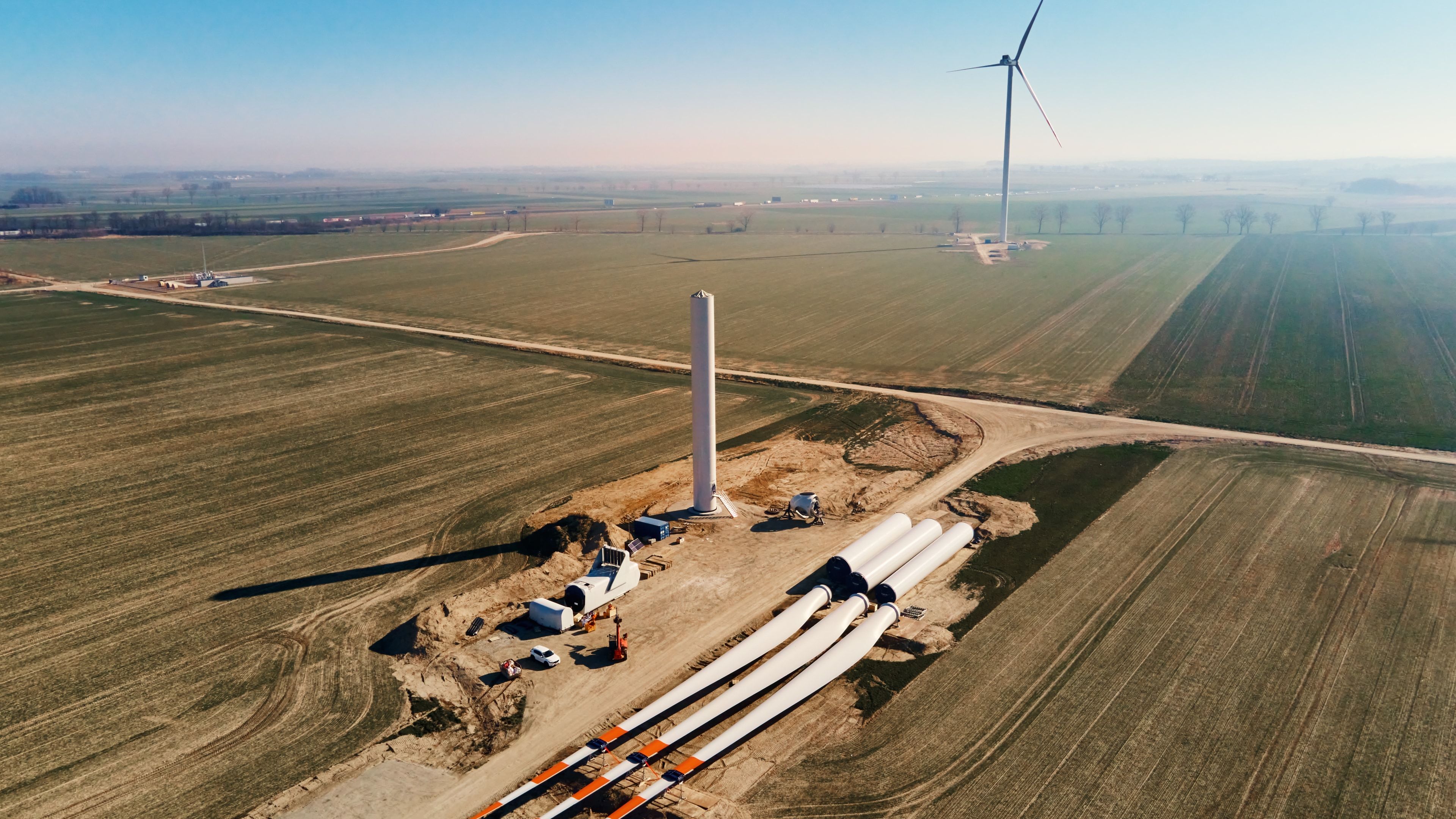 Vista aérea de un parque eólico en construcción con los tramos de torre en el suelo